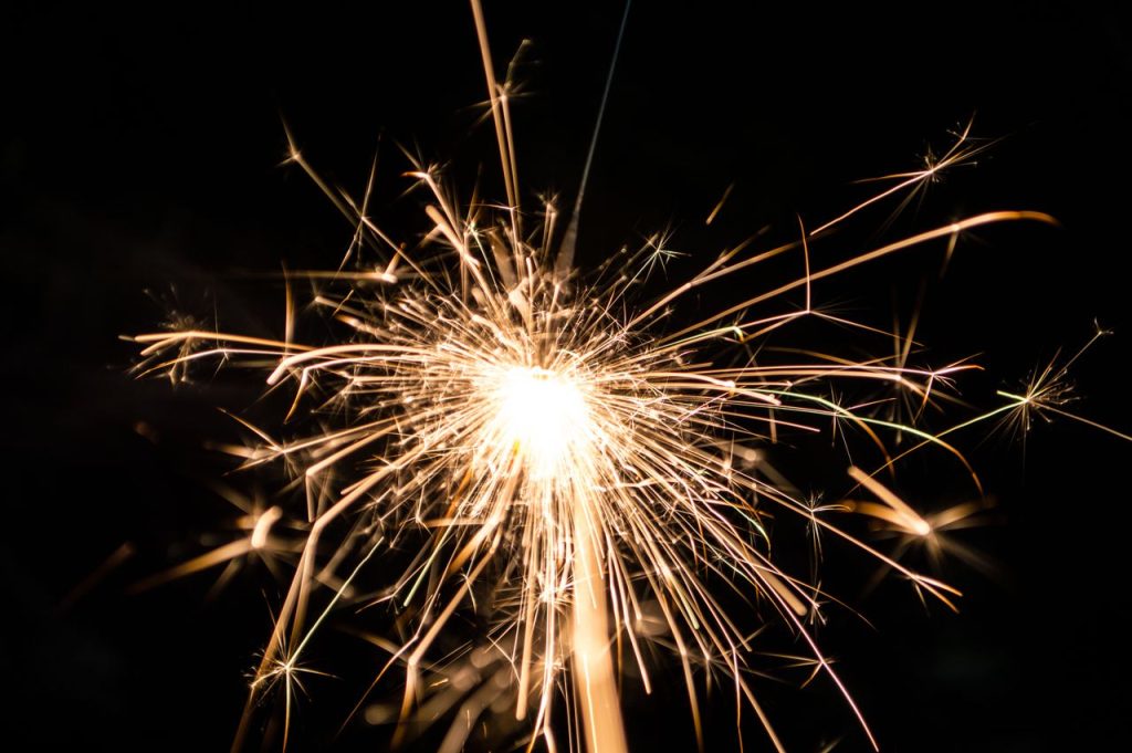 Close-up of a bright firework illuminating a dark night sky, perfect for festive events.